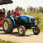 Tractor pulling a wagon ride along a farm lane at Blake's
